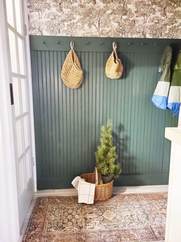 classic bold and moody pantry update with dark green paint bead board paneling, shaker pegs, toilet wallpaper and traditional accents